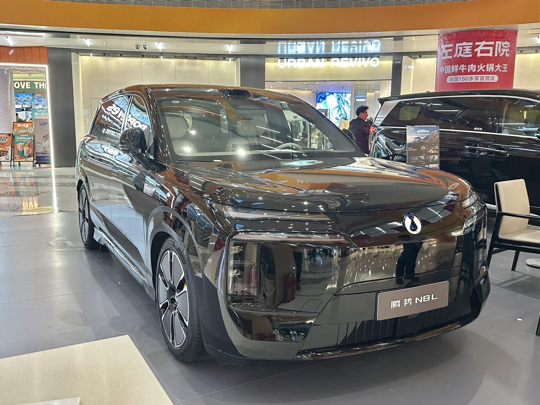 Black Denza N8L on an indoor display, front three-quarter view