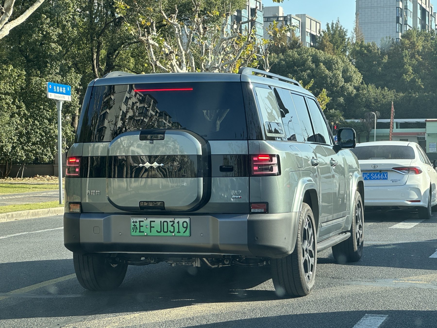 Green Fangchengbao Ti7 on a city street, rear three-quarter view